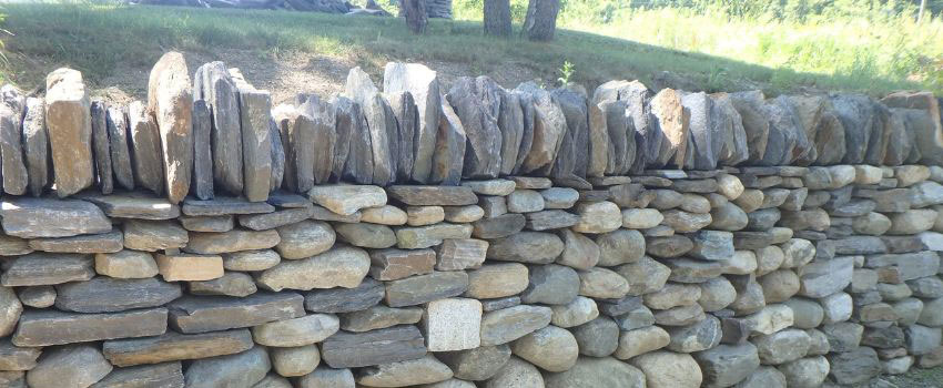 A close-up of a stone foundation in Edmonton, AB with a newly applied sealant and an integrated drainage system to prevent water damage. The sealant is applied to the joints and surface, ensuring long-term protection against moisture.