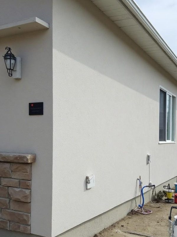 EIFS stucco wall in Fort Saskatchewan AB being professionally painted with a flexible, breathable coating by Depend Exteriors for added durability and aesthetic appeal.
