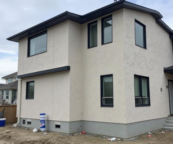 Exterior wall after patching and painting with a uniform finish in Beacon Heights, AB