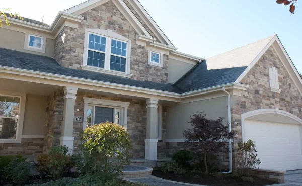 Depend Exteriors painters refreshing the exterior of a two-story Edmonton home with a durable new coat of paint, showing active preparation and painting work.
