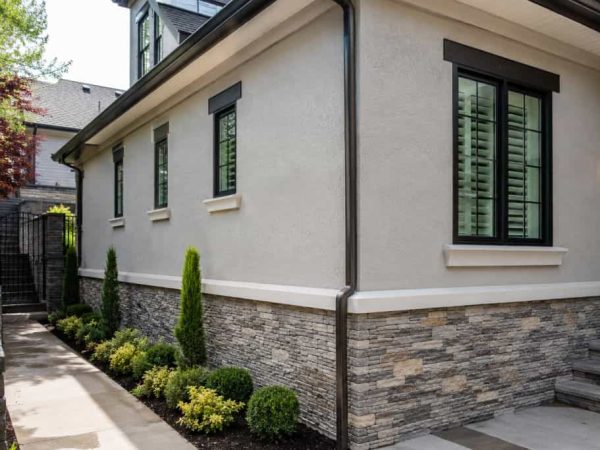 Contemporary home featuring textured stucco and stacked stone masonry on the exterior in Twin Brooks.