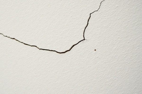 Close-up of stucco wall showing hairline and spider cracks in Edmonton home exterior